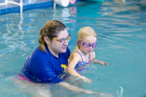 ms kayla teaching survival swim in pool at Little Fins Swim School Colorado