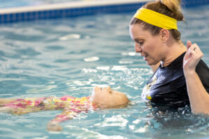 Ms. Kory Little Fins Colorado Springs teaching lifesaving swimming skills to a little girl learning to float