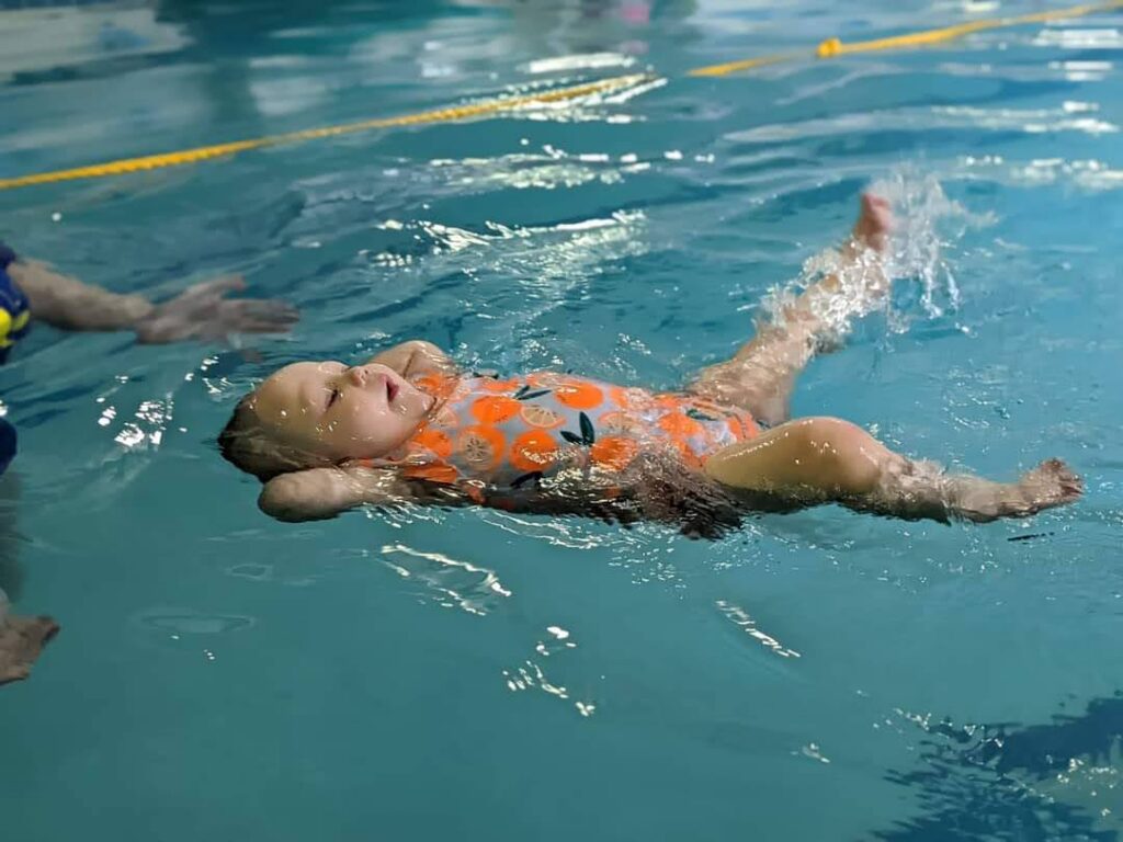 Infant practicing back float during survival swim lesson at Little Fins Swim School in Colorado Springs