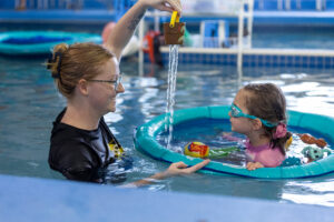 little girl and swim instructor at Little Fins in Colorado Springs at World's Largest Swim Lesson