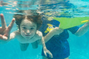 child swimming underwater little fins swim school