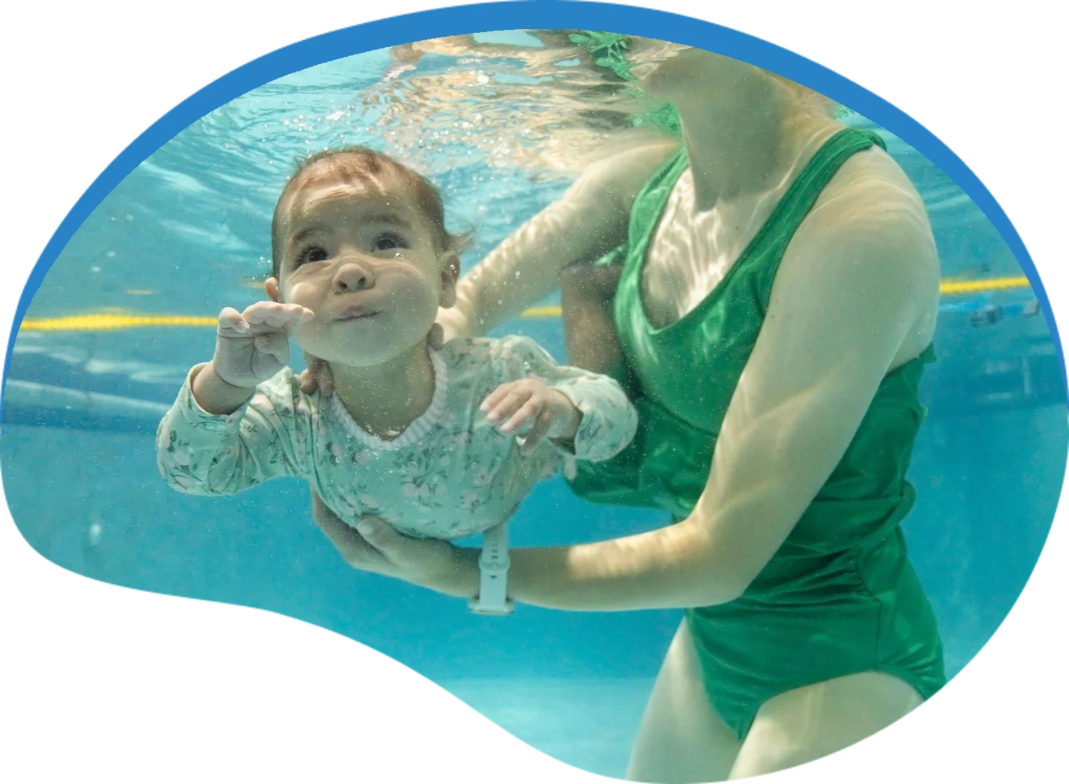 Parent guiding a baby underwater during an Aqua Babies swim lesson at Little Fins Swim School