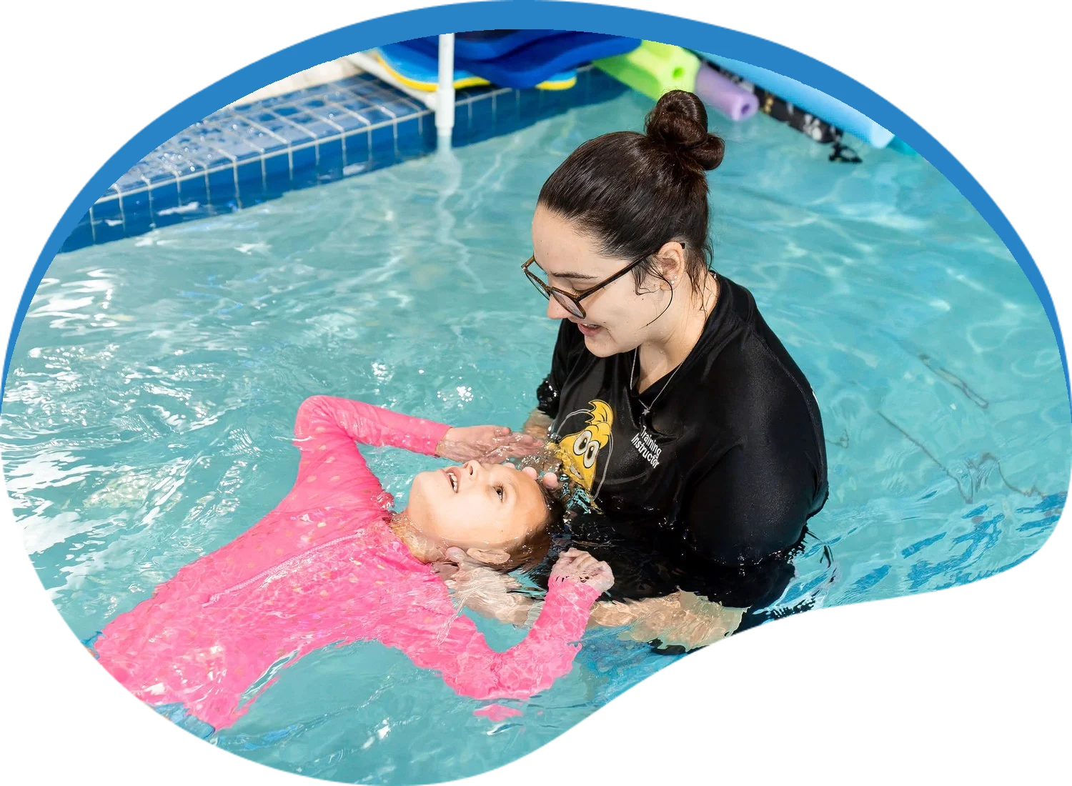 Little Fins instructor supporting a child in a back float during a one-on-one lesson
