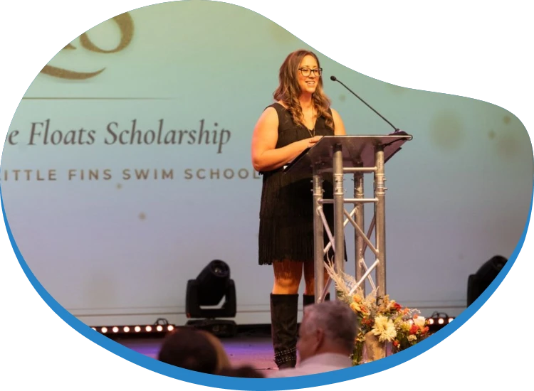 Speaker at the Hope on the Rocks podium in front of the Hope Floats Scholarship slide