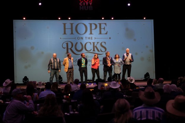 Group on stage in front of the Hope on the Rocks screen